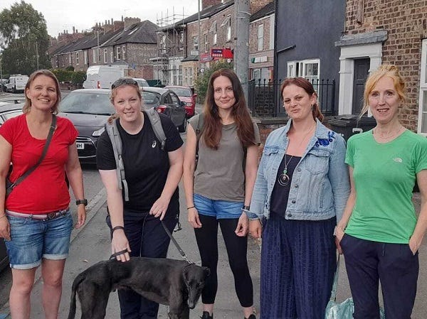 Group of 5 women and a dog on a street