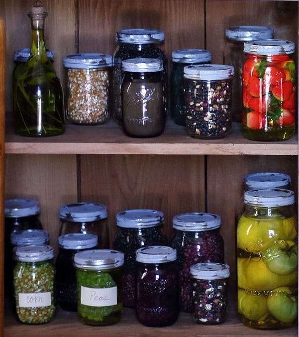 A pantry filled with jars of shelf table staple goods and home canned foods.