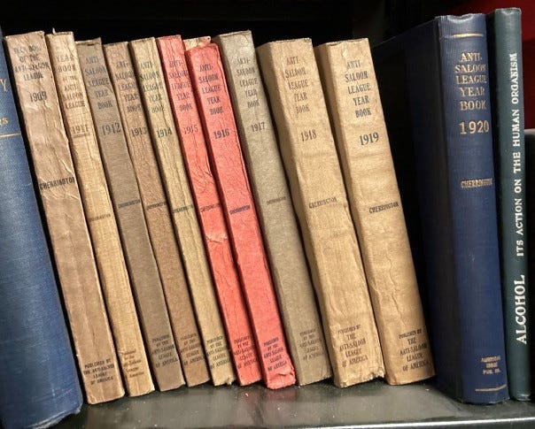 A number of books from 1909 to 1920 leaning together on a bookshelf