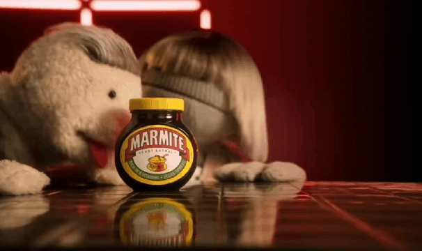 A GIF with the two puppets, one licking a Marmite Jar and text saying ‘Love it. Hate it. Get it on.’