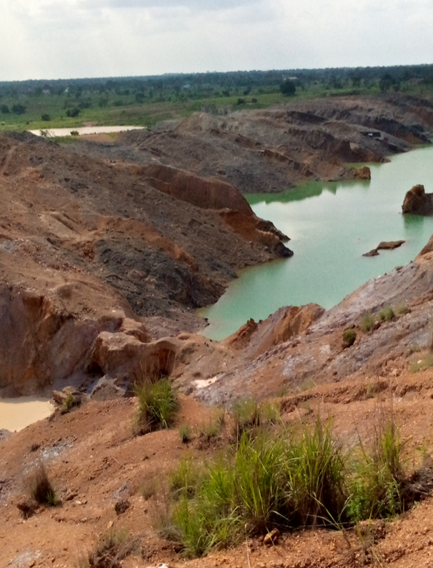 rocky mountains at a mining site in Nigeria, turquoise water with brownish water in between rocky mountains