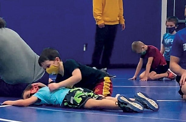 Calahan Cornelius, age 5, (putting in a half-nelson) and Maxwell Schmitz, 6, are learning the sport at wrestling club in Bellevue, Iowa.