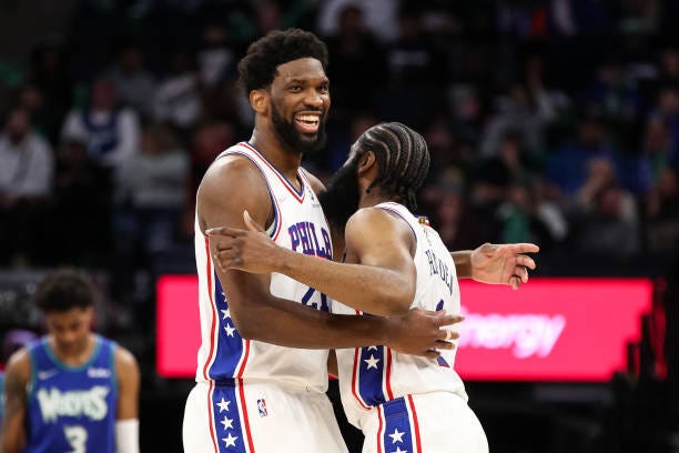 A picture of two African American basketball players embracing: Joel Embiid and James Harden, the star duo of the Philadelphia 76ers NBA team