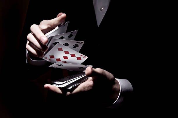 A magician doing his tricks with his two hands by quick shuffling cards.