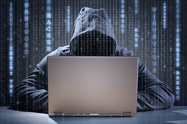 An image of a hacker with a laptop