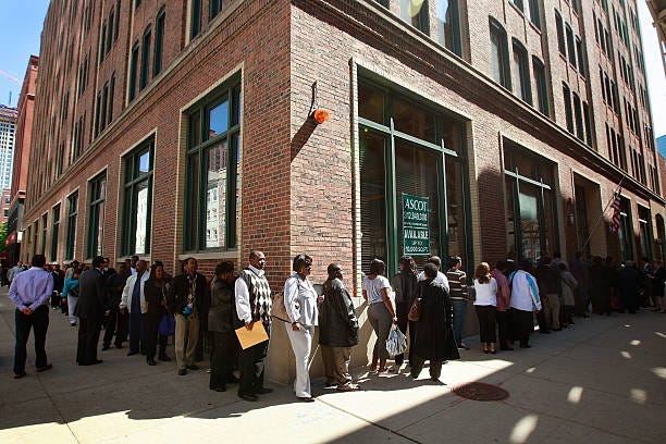 People standing in line waiting to file unemployment benefits due to COVID-19.