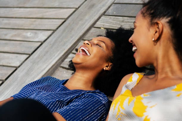 Two black women enjoying a heartful laugh.