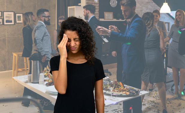 A frustrated person is grimacing with their hand on their forehead. In the background is a transparent scene of an office party.