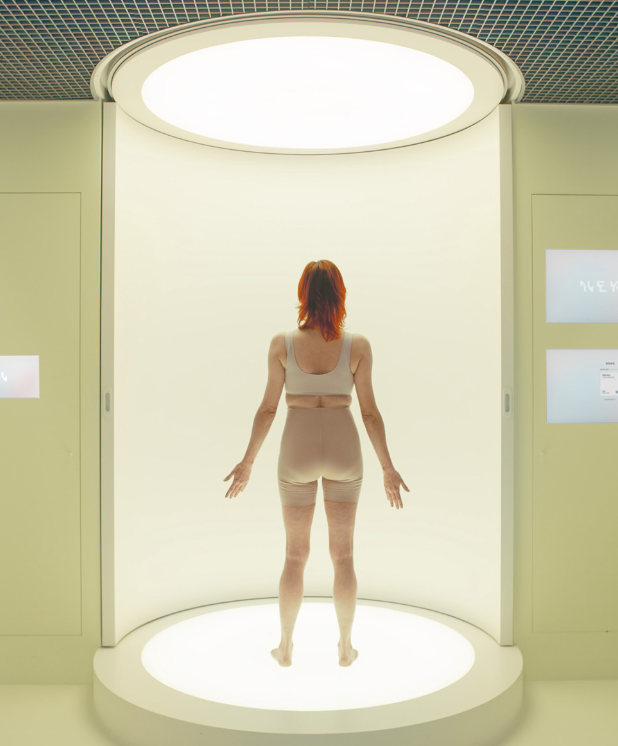 a woman standing in a Neko body scanner for wellness analysis using AI