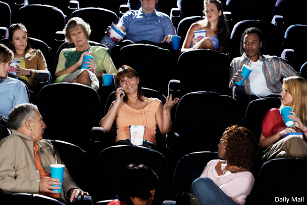 Woman talking on the phone, while others are trying to watch a movie