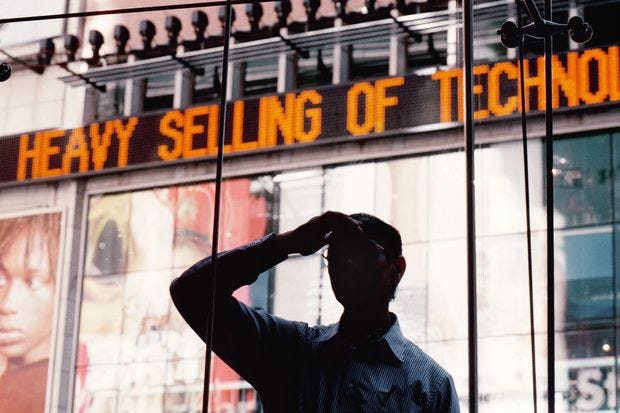 A man observing a distant place, behind which is a sign that reads “Heavy sell”.