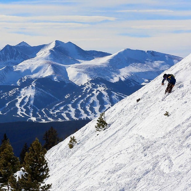 A skier going down the slopes at Keystone resort in Colorado. Beautiful view of the mountains in the background.