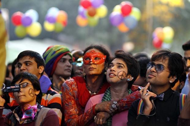 People from the LGBTQ community of India look up as balloons float in the background