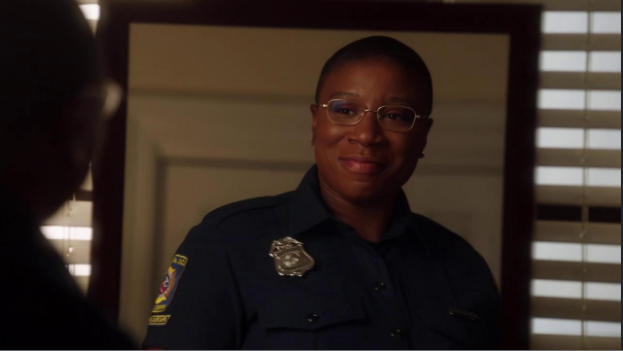 Firefighter Henrietta Wilson, played by Aisha Hinds, looks herself in the mirror with a smile.