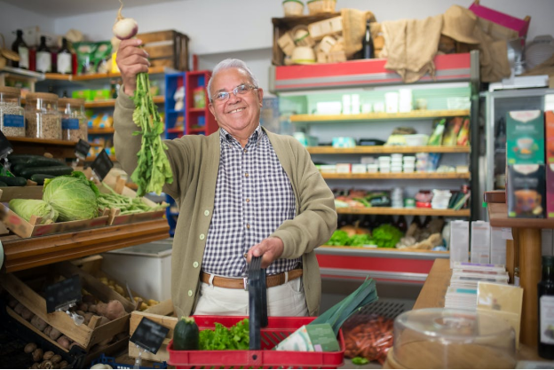 An elderly man shopping for vegetables