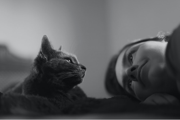 A woman and a cat looking at each other
