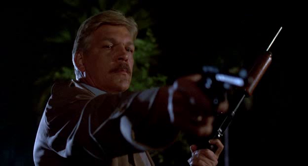 detective Ray Cameron played by Tom Atkins aiming his gun