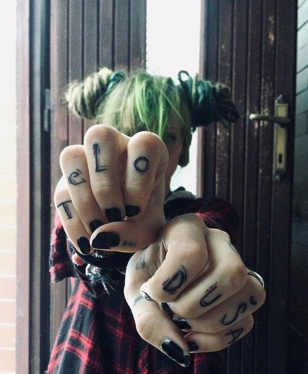 Alternative girl with finger tattoos and green dreads