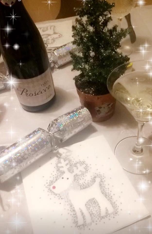 Christmas place setting with crackers, Prosecco and a martini glass