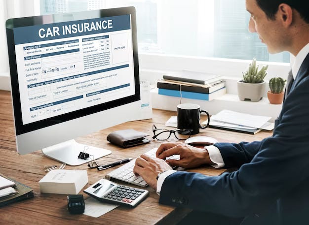 An insurance agent on his computer working on a car insurance