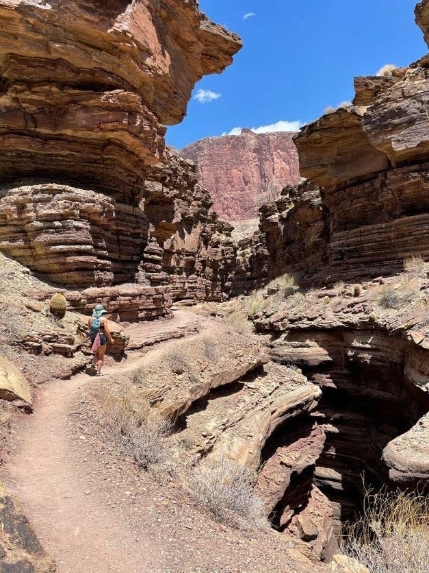 A woman hiking along the narrows between cliffs