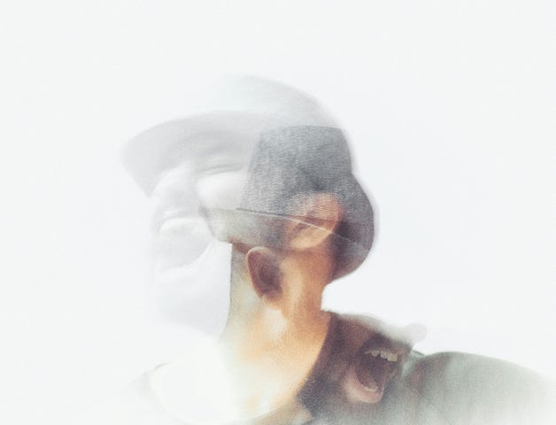 A vague double-exposure of a man yelling.