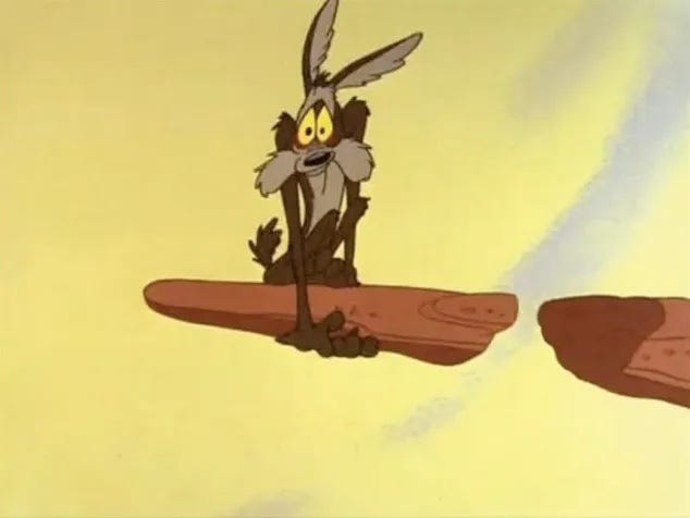 A cartoon still. Wile E. Coyote Hovers Mid-air waiting to Fall. Looney Tunes. Time-Warner Media.