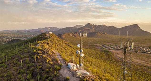 Aerial view of 5G connected towers on a remote mountain landscape