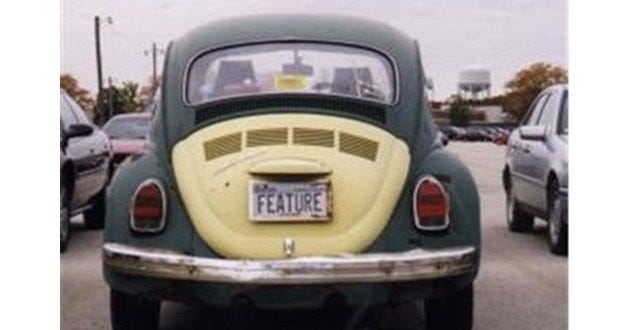 A Volkswagen Beetle with license plate that reads Feature