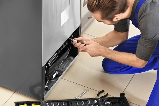 Qualified technician performing fridge repairs in Kingswood

