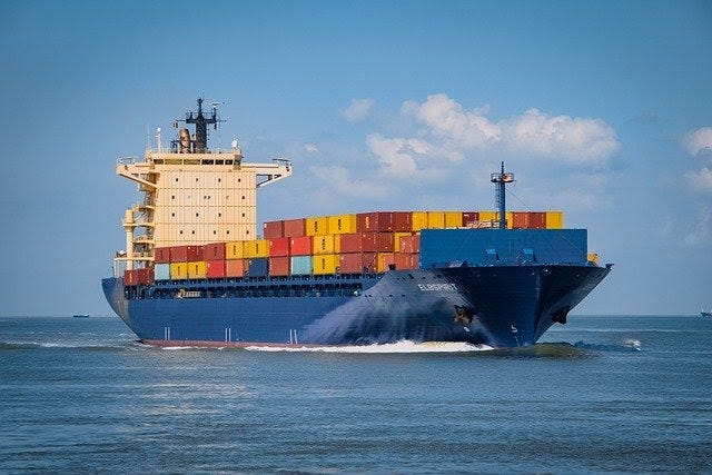 Image of a blue container ship carrying brightly colored containers.