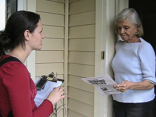 A canvasser speaks with an older woman