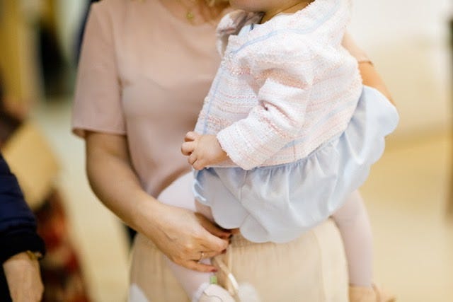 Uma mãe segurando sua filha no colo.