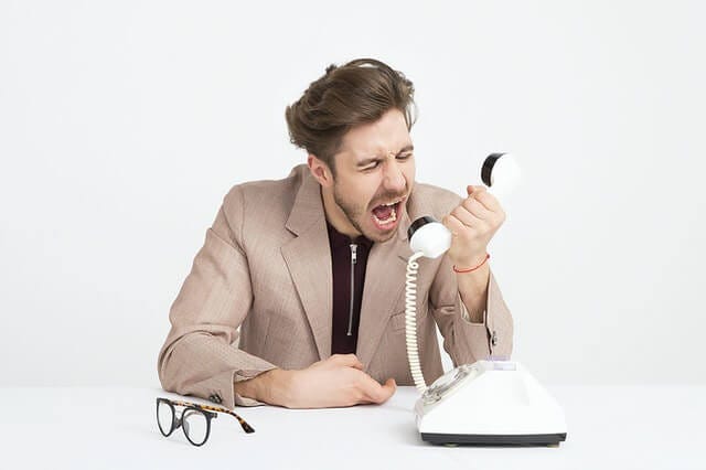 Man yelling at phone in anger.