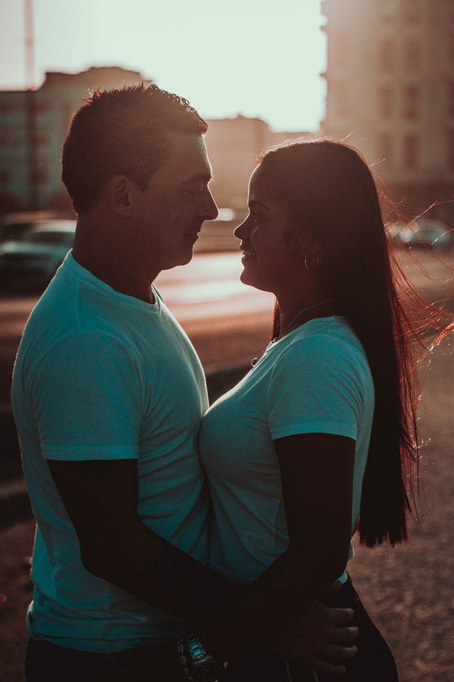 A man and a foreign woman in white shirts, embracing each other