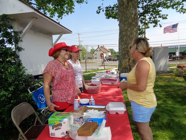 Eileen Chesla and Carolyn Cuviello serve shortcake to a patron.