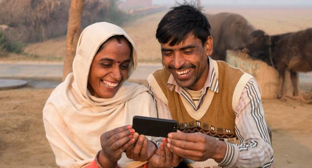 An Indian couple looking in mobile in a village in India