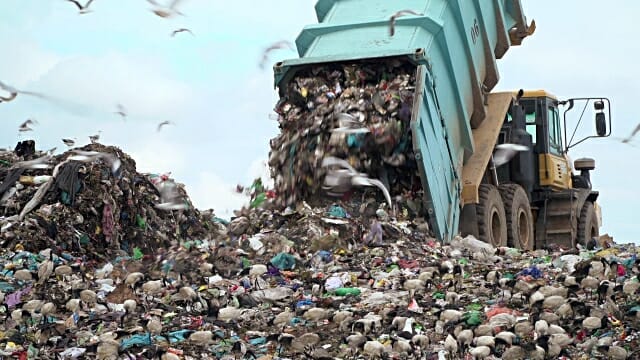 Garbage truck dumping garbage at a dump