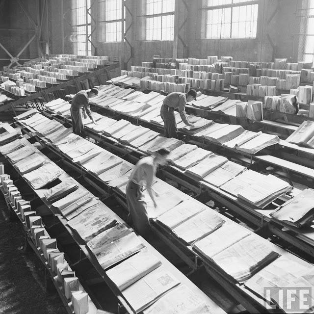 Men drying out state library books damaged by fighting the Lewis Cass State Office Building fire in Michigan, 1951.