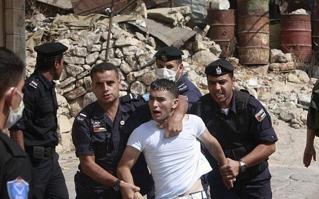 La policía política de Abás detiene a un manifestante palestino en el curso de unos enfrentamientos con fuerzas israelíes en Hebrón. (Foto: Naser Shiyuji / AP)