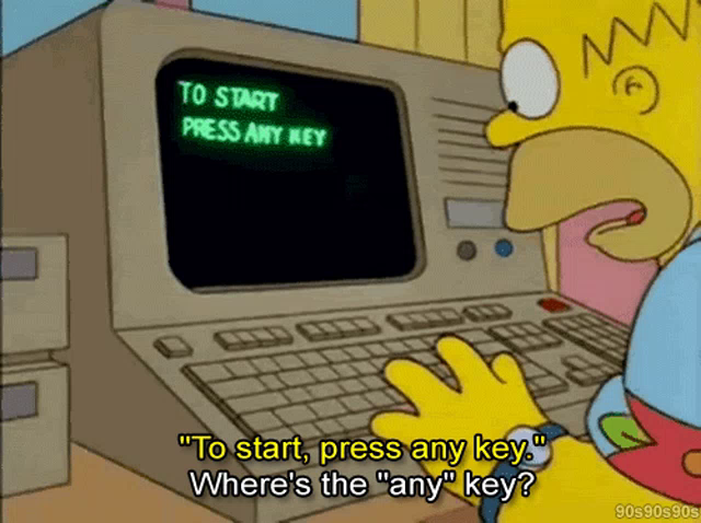 Imagem do Homer sentando em frente a um computador bem antigo. Na tela preta aparecem letras verdes dizendo “To start press any key”. Homer responde Where’s the “any” key