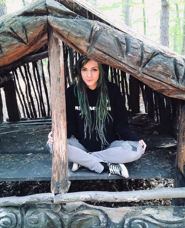 Dread head girl sitting in the wooden house