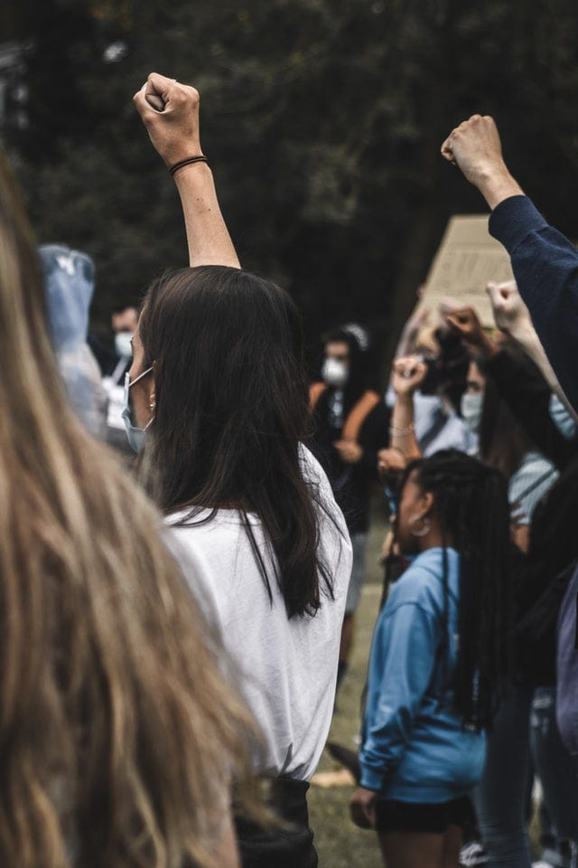 Masked people of color with fists in the air