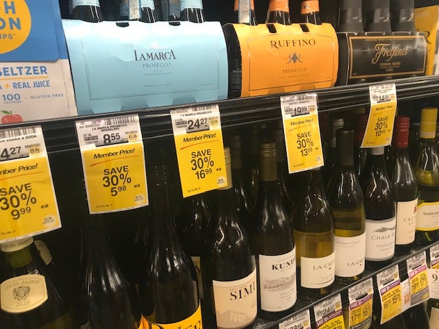 Several shelfs of wine in grocery store.