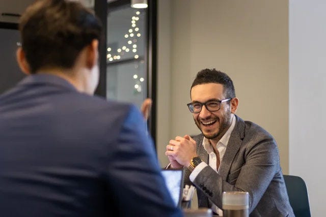 Man laughing with friend in the office