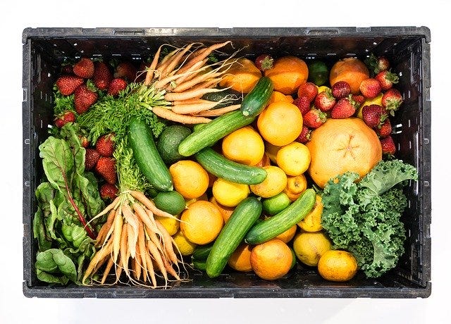 Box full of various fruits and vegetables.