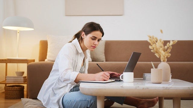 woman with laptop and notebook studying