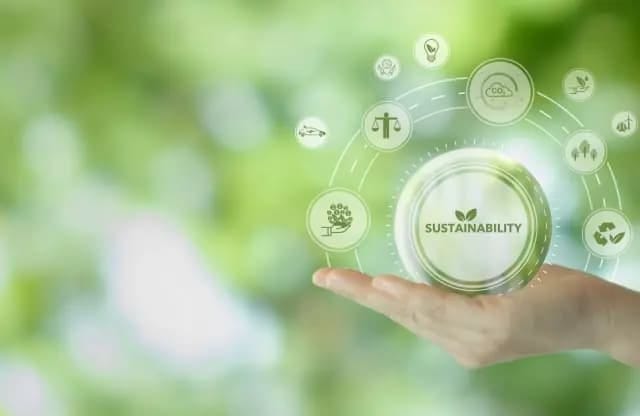 A hand holds symbols of sustainability.