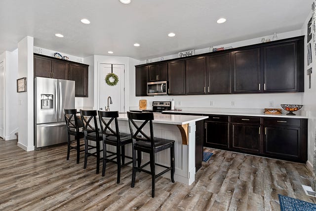 Modern kitchen of a Home for Sale in Layton Utah featuring lots of cabinetry and large kitchen island…