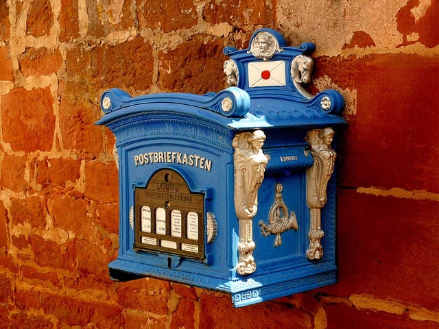 An old mailbox on a brick wall